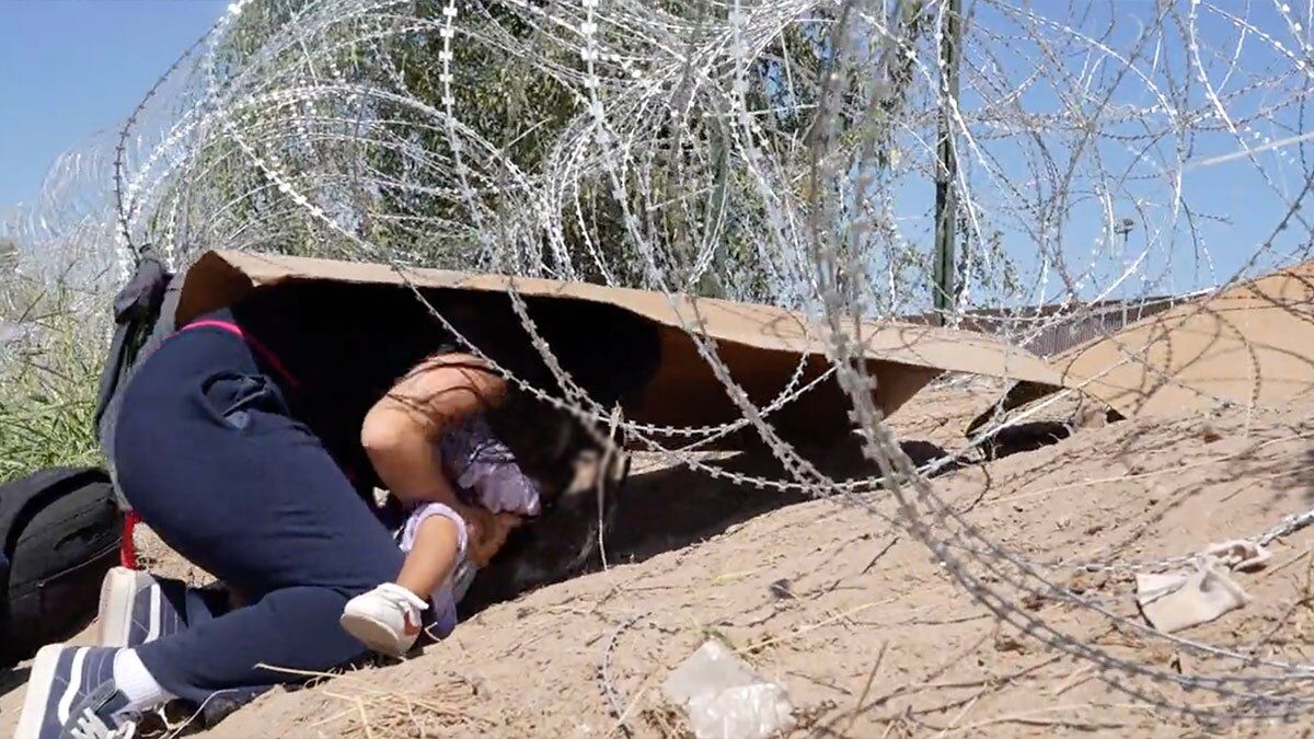 Video | Mujer con su bebé en brazos intenta cruzar bajo un alambre de púas para cruzar la frontera con Texas 